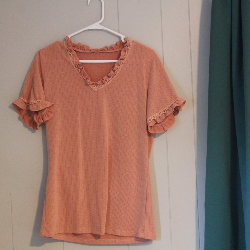 Ruffle neckline and short sleeve hem on peach blouse